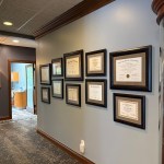 wall with rows of framed certificates